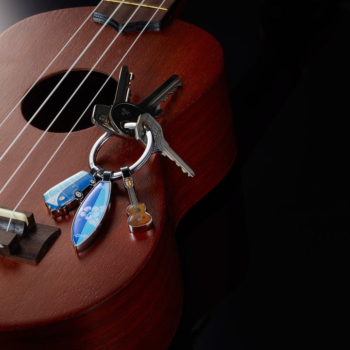 Troika Surfmate T1, Keychain with VW T1 Van, Surfboard and Guitar Charms. Image shows keychain on a guitar. Troika Item KR16-14/CH 