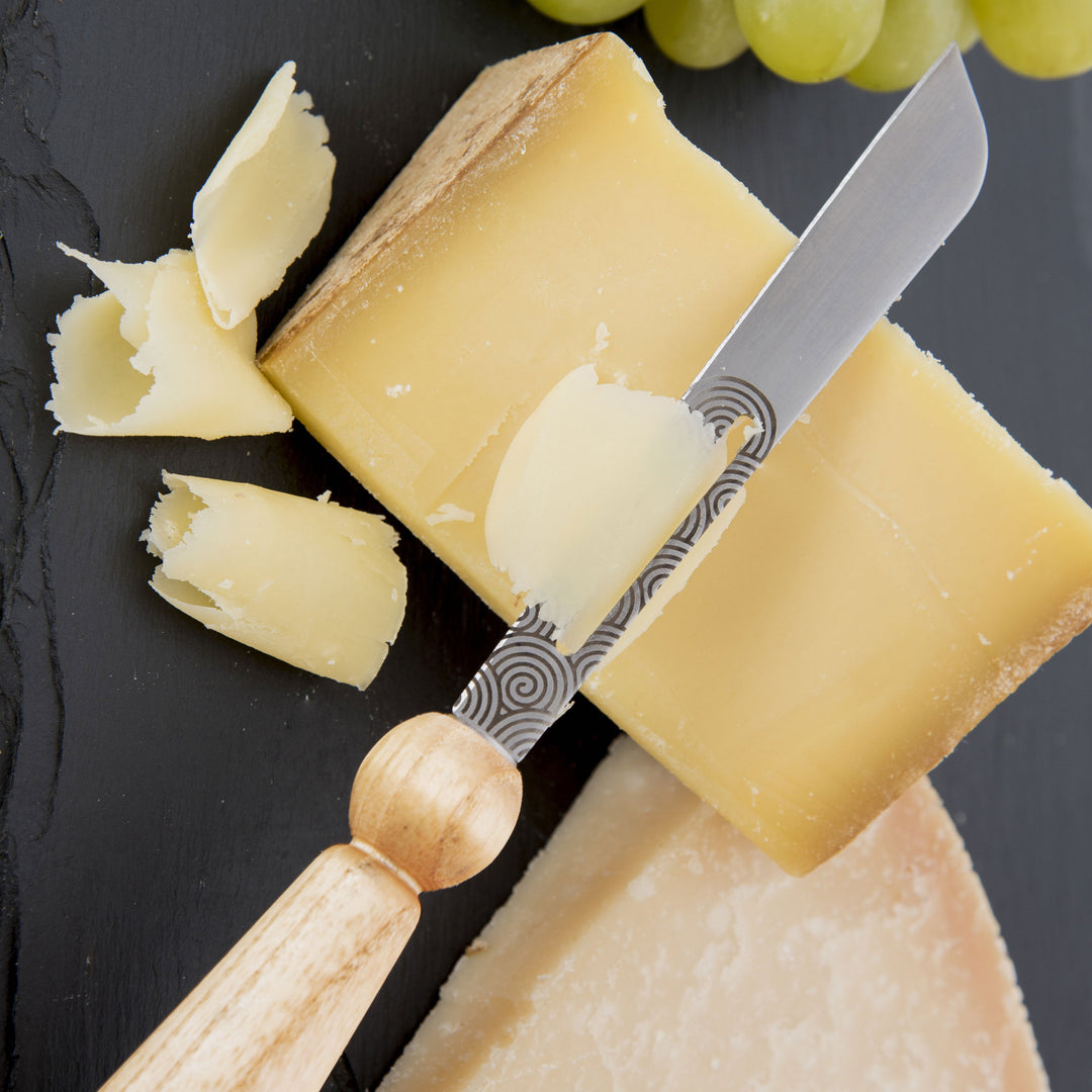 lib editeur d'idees YANA cheese knife made in France. Shown slicing a hard cheese.